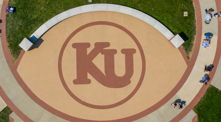 photo of KU Plaza from overhead. Gold brick forming a football shape with maroon brick in KU logo.