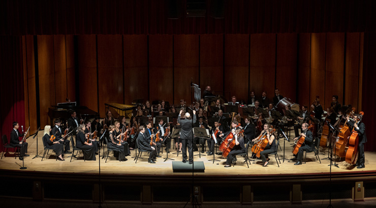 KU orchestra performing on Schaeffer Auditorium stage