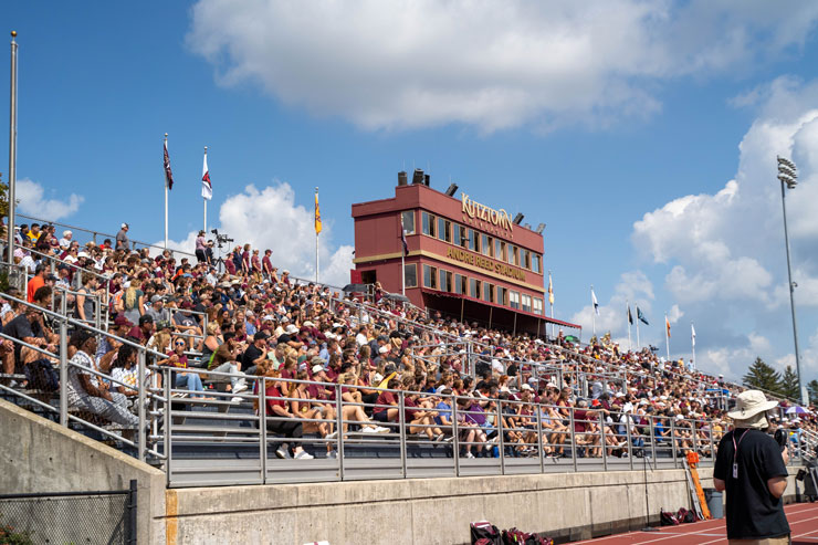 A crowd of spectators sitting in the stands with the Andre Reed Stadium sign in the background.