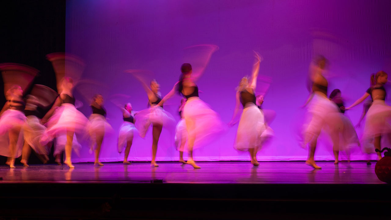 group of dancers in action, their movement blurred artistically.
